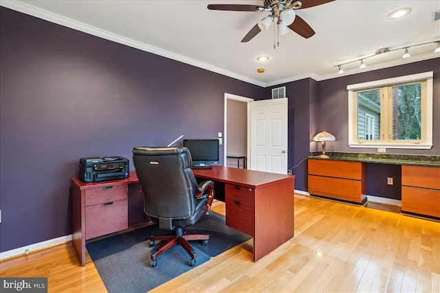 office space featuring crown molding, track lighting, ceiling fan, and light hardwood / wood-style floors