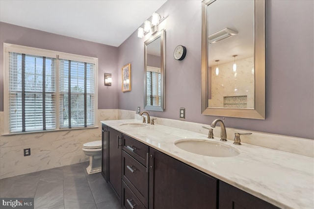 bathroom featuring tile patterned floors, toilet, tile walls, and vanity