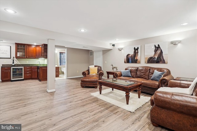 living room with indoor bar, wine cooler, and light wood-type flooring