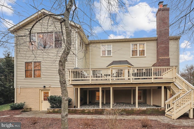 rear view of property featuring a wooden deck