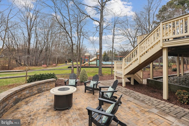 view of patio / terrace with a playground and an outdoor fire pit