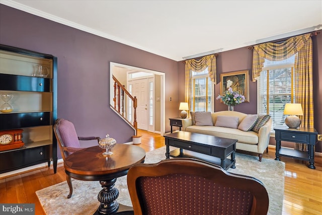 living room featuring hardwood / wood-style flooring, ornamental molding, and plenty of natural light