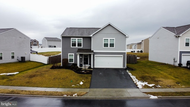 traditional-style home featuring aphalt driveway, a front yard, a residential view, and a garage