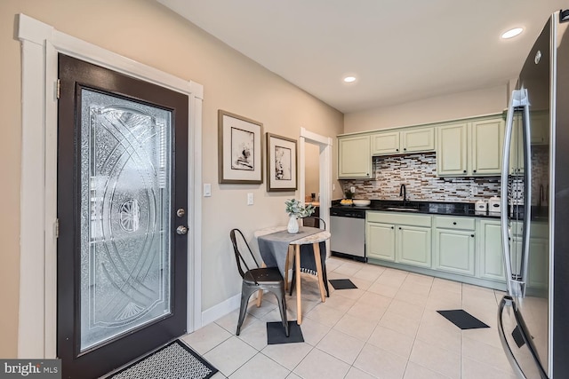 kitchen with sink, dishwasher, backsplash, green cabinetry, and black fridge