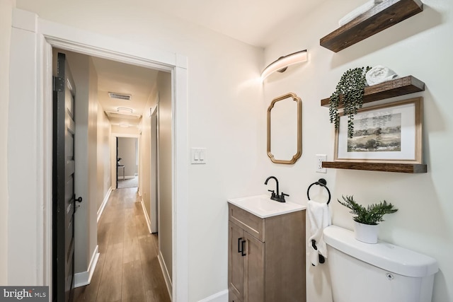 bathroom with vanity, toilet, and hardwood / wood-style floors