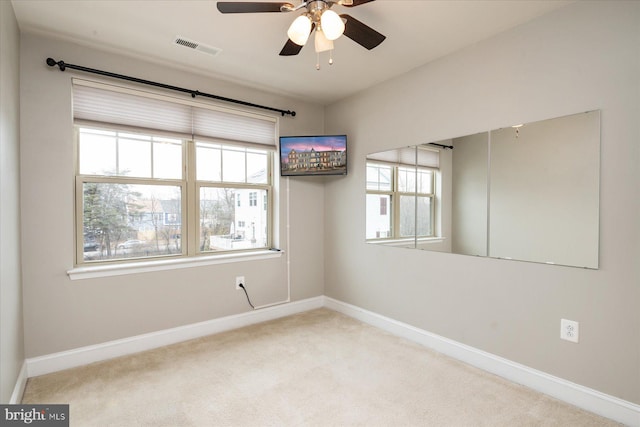 unfurnished room featuring light colored carpet and ceiling fan