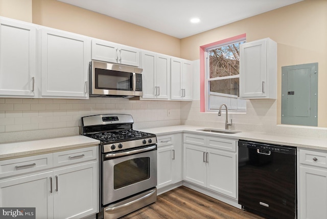 kitchen featuring appliances with stainless steel finishes, dark hardwood / wood-style floors, white cabinetry, sink, and electric panel