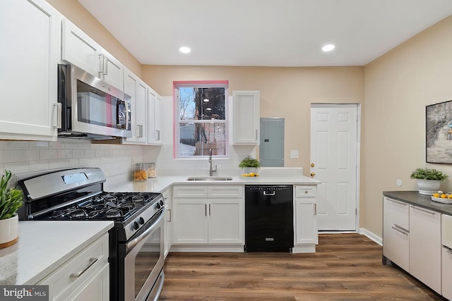 kitchen with sink, appliances with stainless steel finishes, dark hardwood / wood-style floors, white cabinets, and decorative backsplash