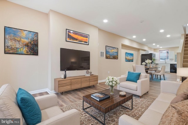 living room with sink and light hardwood / wood-style flooring