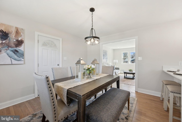 dining area featuring light wood-style flooring and baseboards