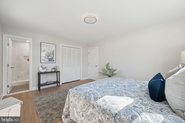 bedroom featuring ensuite bath, a closet, wood finished floors, and baseboards