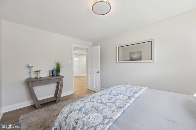 bedroom with baseboards and wood finished floors