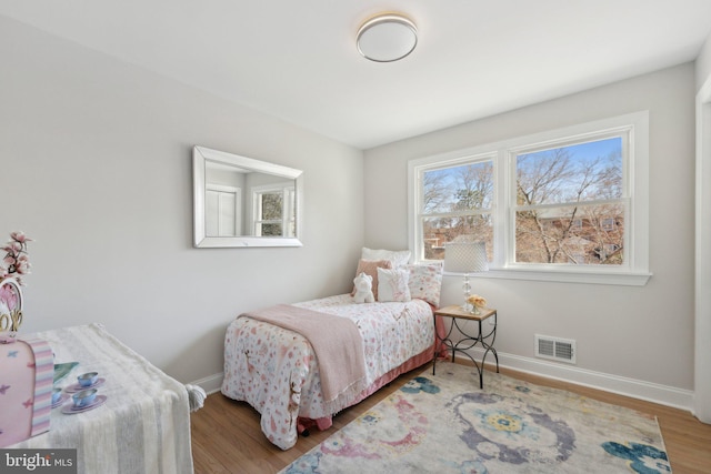 bedroom featuring visible vents, baseboards, and wood finished floors