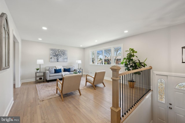 living room with baseboards, light wood finished floors, and recessed lighting