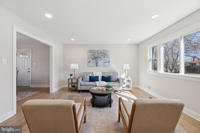 living area featuring baseboards, recessed lighting, visible vents, and light wood-style floors