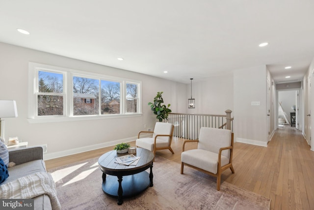 sitting room with baseboards, recessed lighting, and light wood-style floors