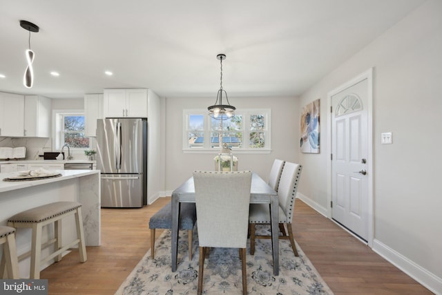 dining area featuring light wood-style floors, a wealth of natural light, and baseboards