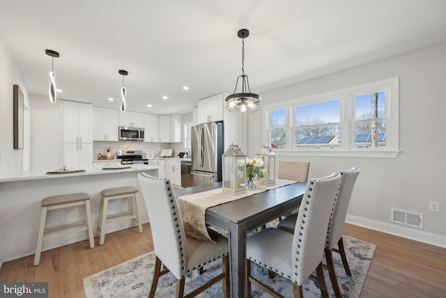 dining room featuring recessed lighting, visible vents, baseboards, and wood finished floors