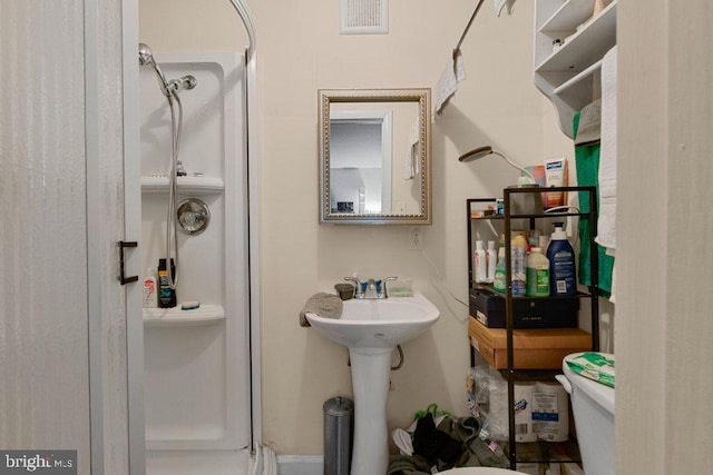 bathroom featuring sink, toilet, and walk in shower