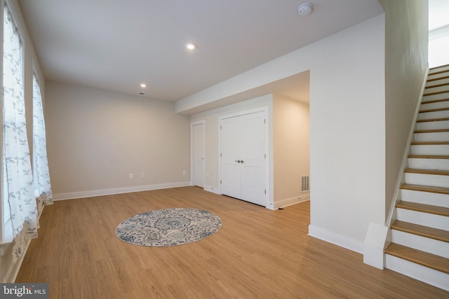 interior space featuring stairs, visible vents, light wood-style flooring, and baseboards