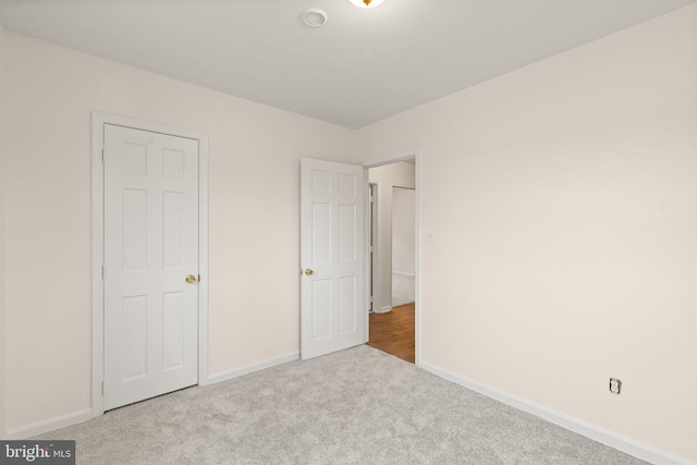 unfurnished bedroom featuring carpet and baseboards