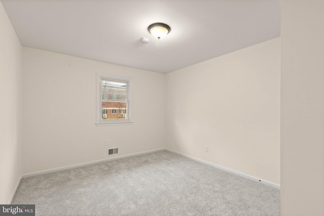 spare room featuring carpet, visible vents, and baseboards