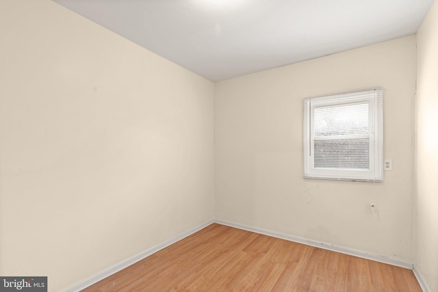 spare room featuring light wood-style flooring and baseboards