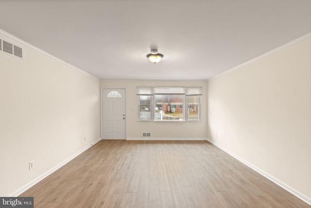 unfurnished living room featuring crown molding, light wood finished floors, visible vents, and baseboards