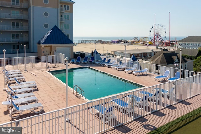 view of pool with a water view and a patio