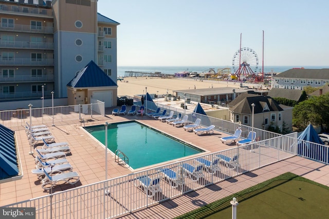 view of swimming pool with a patio and a water view