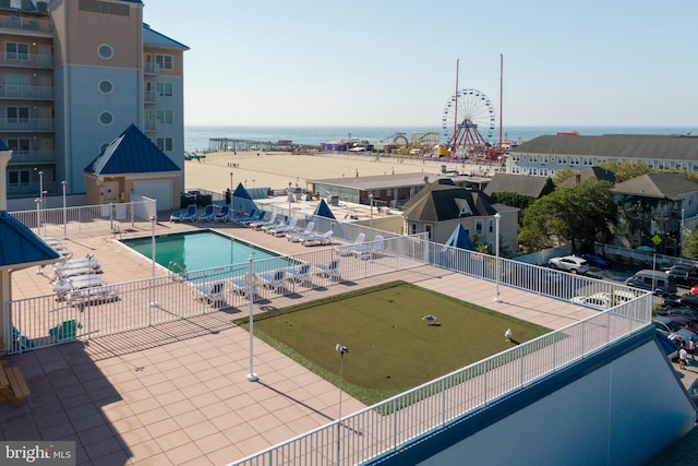 view of pool with a patio and a water view