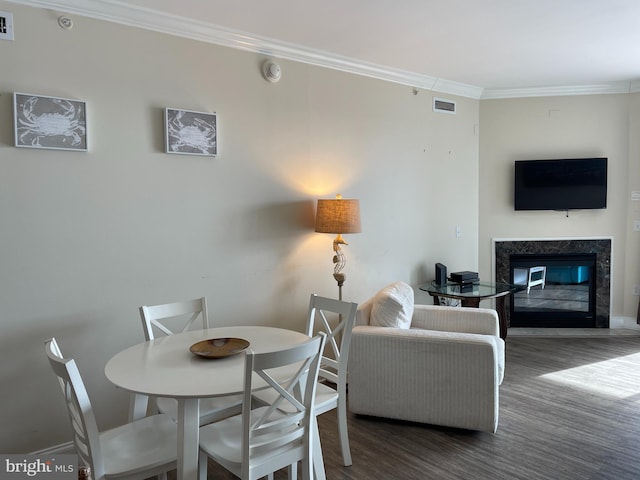 dining room with crown molding, a high end fireplace, and dark hardwood / wood-style floors