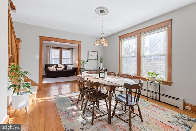 dining room with a baseboard radiator and light hardwood / wood-style floors