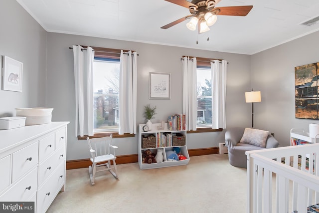 bedroom with ceiling fan, a baseboard radiator, light carpet, and a crib