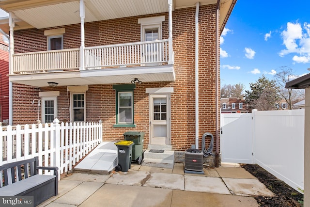 back of property with a patio, a balcony, and cooling unit