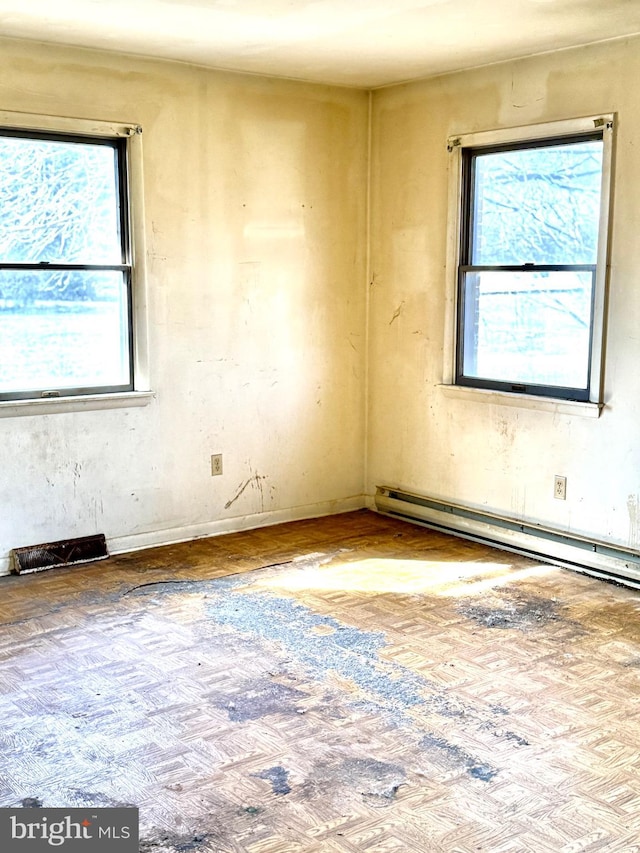 empty room with plenty of natural light and a baseboard heating unit