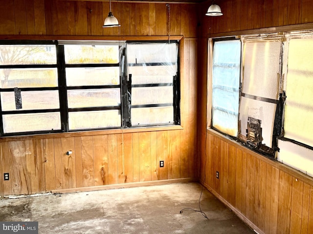 spare room with concrete floors and wood walls