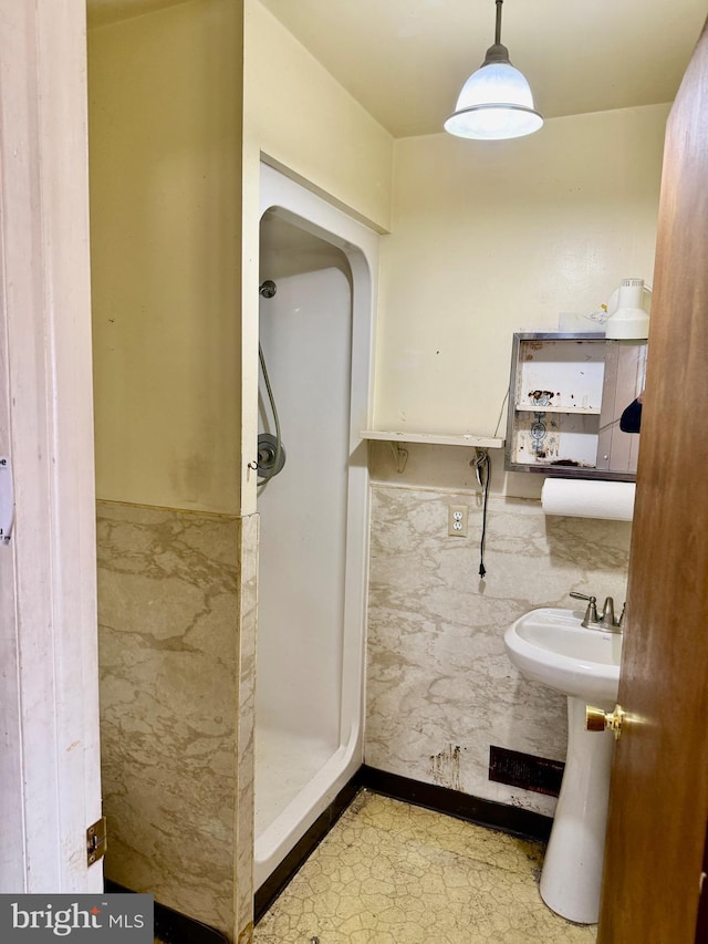 bathroom featuring tile walls and a shower