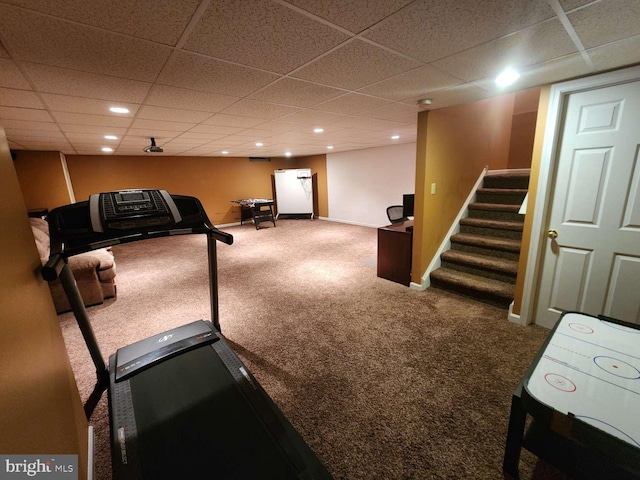 workout room featuring carpet flooring and a paneled ceiling