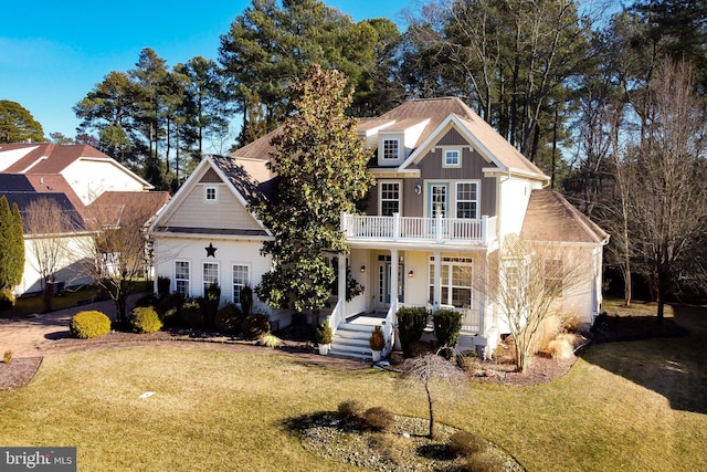 view of front of house featuring a balcony, a porch, board and batten siding, and a front yard