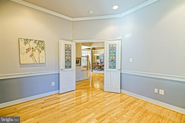 empty room with ornamental molding, baseboards, and wood finished floors