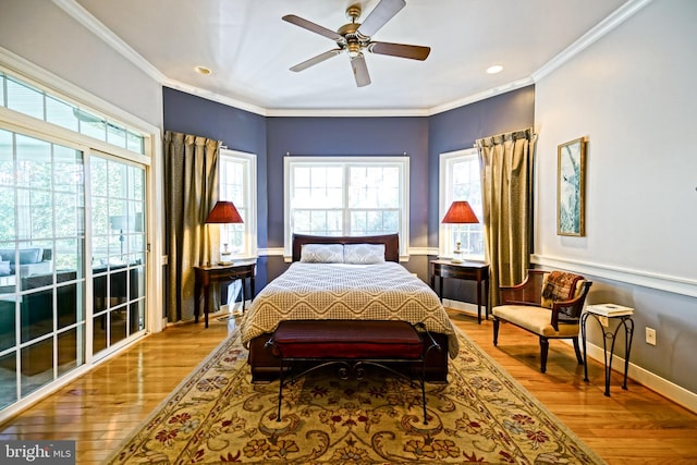 bedroom featuring ornamental molding, multiple windows, and wood finished floors