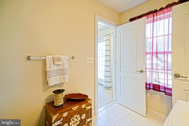 doorway to outside with baseboards and tile patterned floors