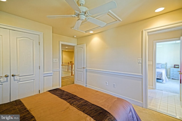 bedroom with light tile patterned flooring, recessed lighting, light colored carpet, a ceiling fan, and attic access