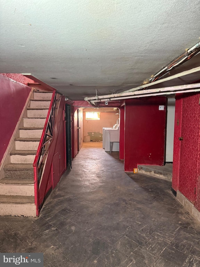 basement with washer / clothes dryer and a textured ceiling