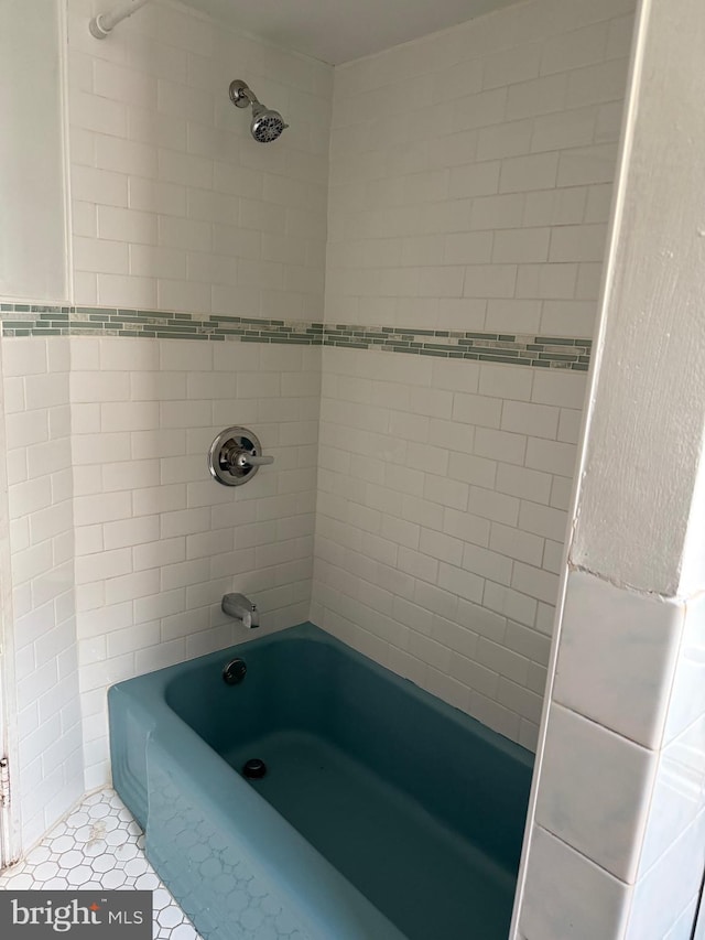 bathroom with tiled shower / bath, tile patterned floors, and tile walls