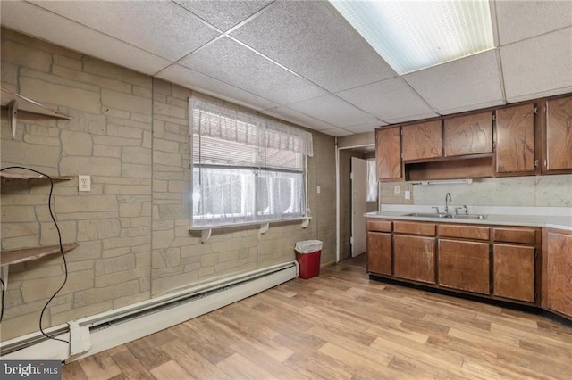 kitchen with a baseboard radiator, a paneled ceiling, sink, and light hardwood / wood-style flooring