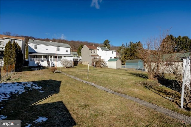 view of yard featuring a porch and a storage unit