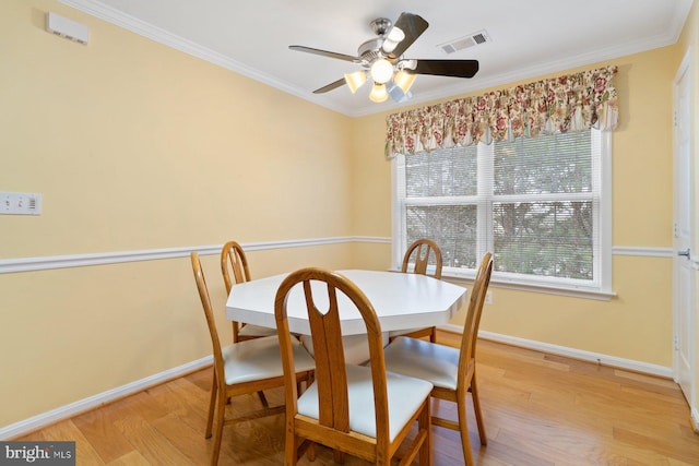 dining area with baseboards, ornamental molding, visible vents, and light wood-style floors