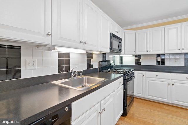 kitchen featuring black appliances, dark countertops, and white cabinetry